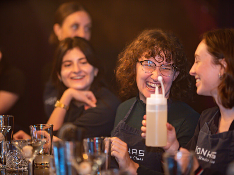 People laughing at a team building cocktail making class in London